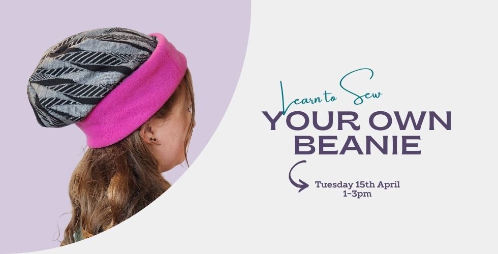 Girl wearing a black and grey beanie with hot pink band